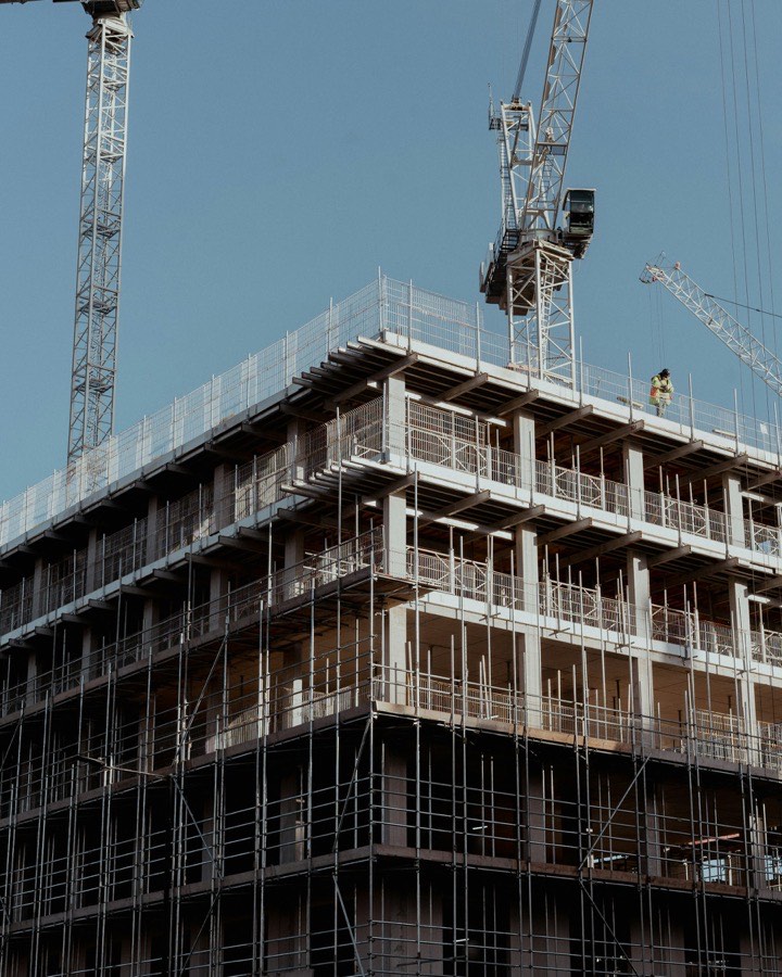 A concrete frame under construction with a tower crane above it