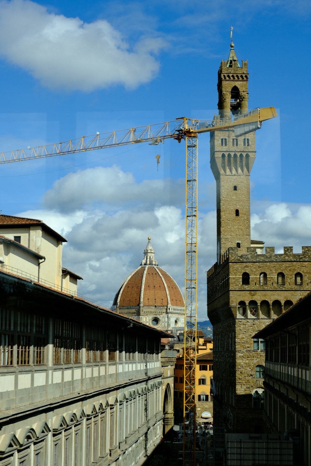 Florence rooftops with the cathedral dome and a tower crane over a building site