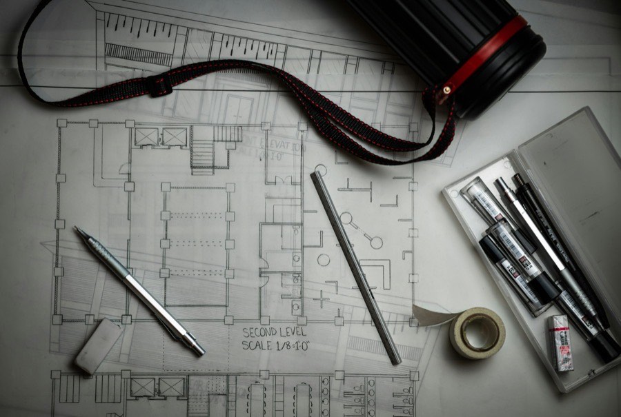 Construction drawings on a desk with a straightedge laid across them